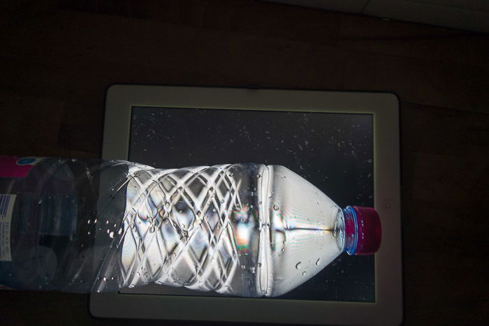 A PET drink bottles in front of a laptop screen