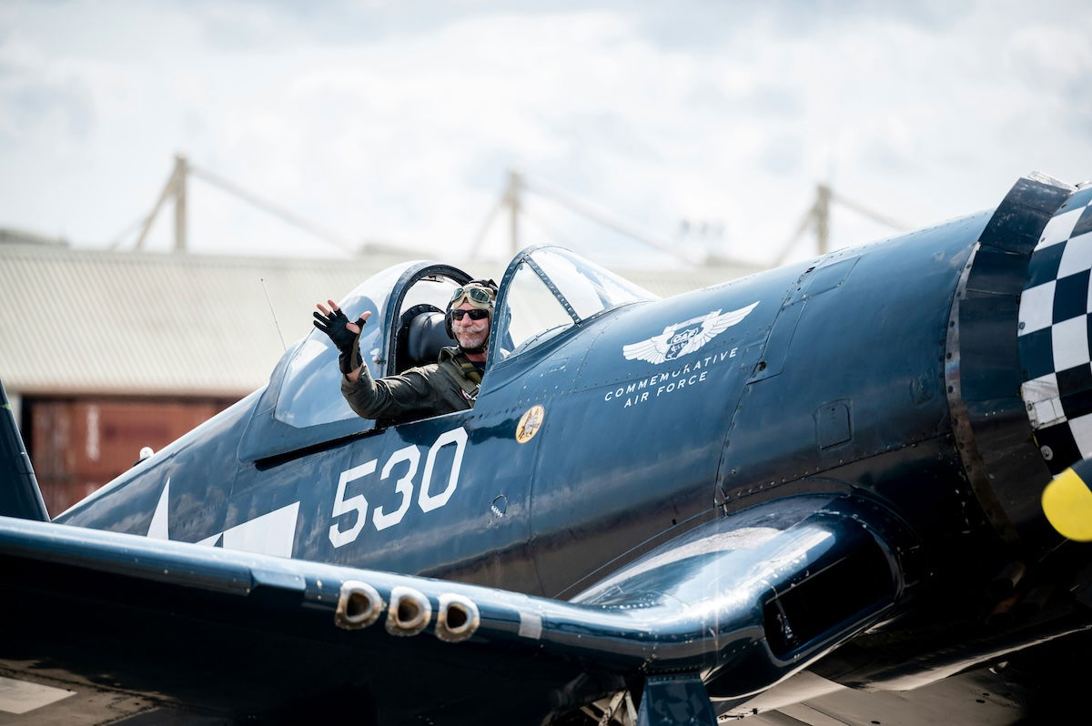 A pilot waving from a fighter plane cockpit as an example of aviation photography