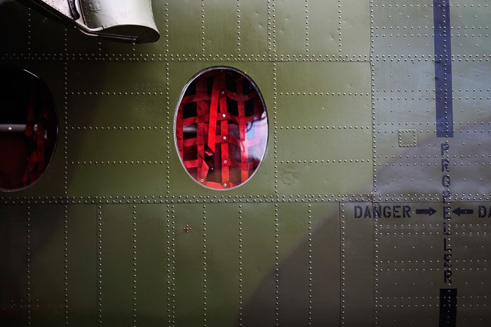 Cargo webbing visible through the window of a military plane.