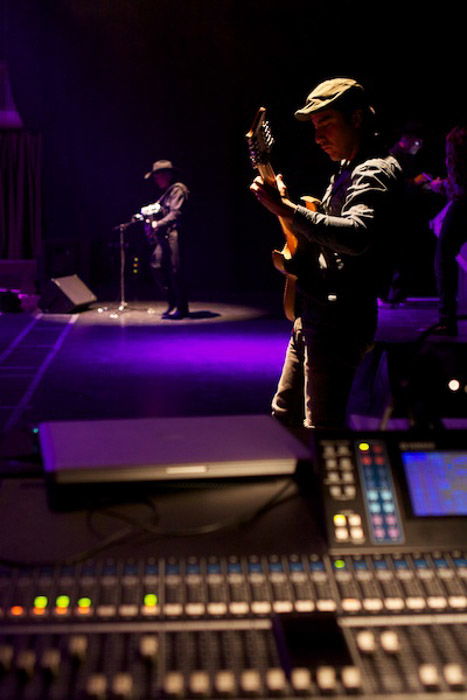 Photo of two people on a stage playing guitars