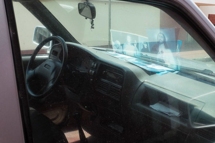 Pictures reflected in the windshield of a parked car.