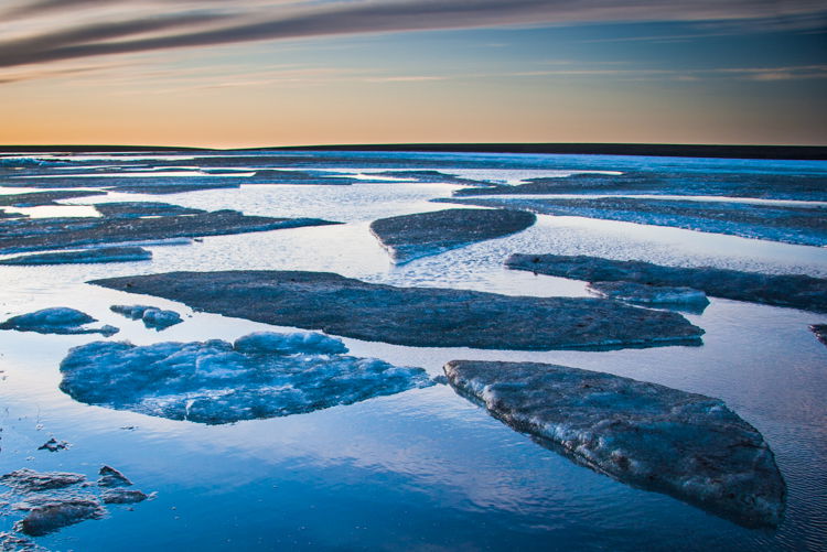 Sunset over a river covered with icecaps occasionally