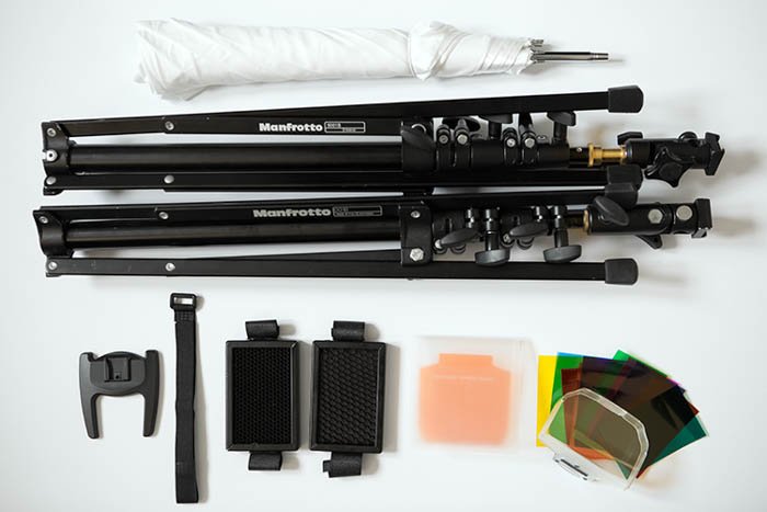 assortment of photography accessories, including Manfrotto light stand and a flash gels filter kit