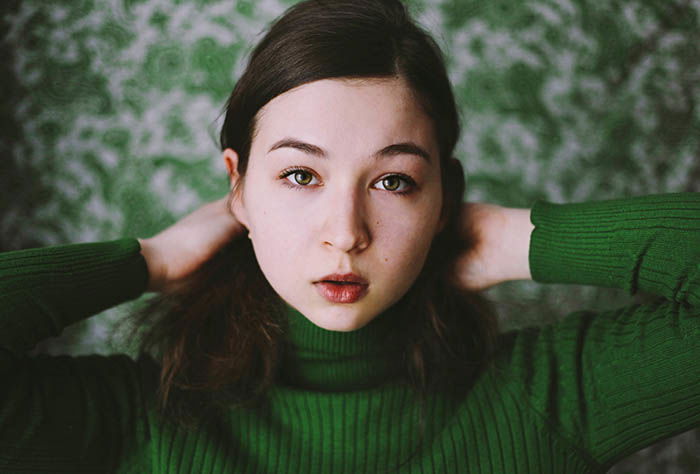 A girl poses for self portrait photography emphasising the use of only one colour, green