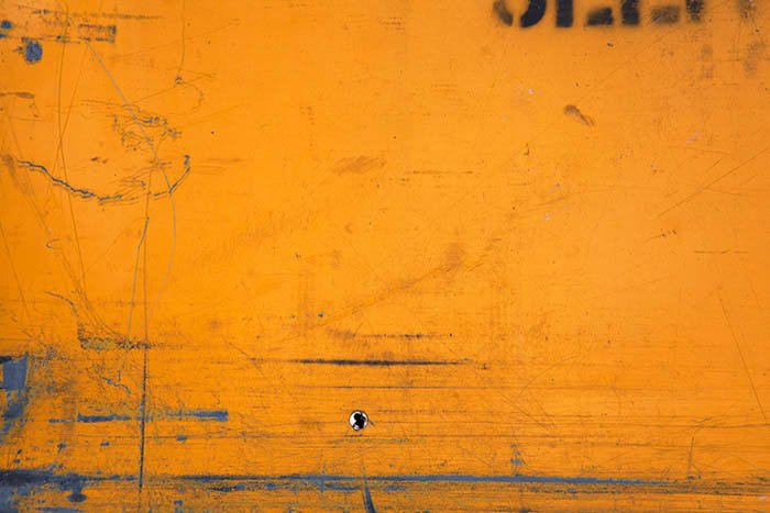 street photography composition idea: close-up of an orange bollard