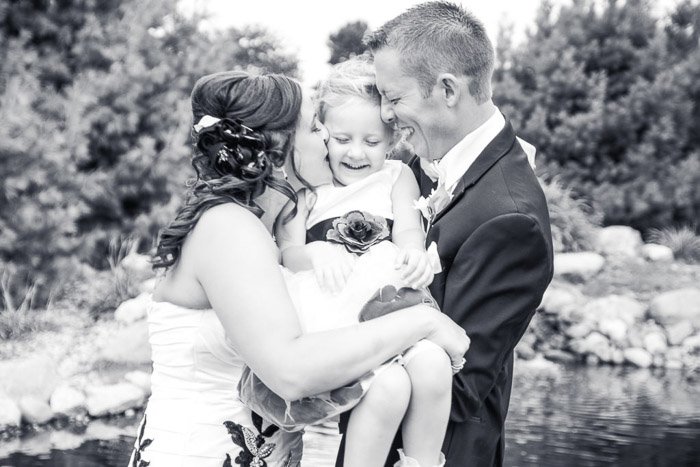 Black and white wedding photo of a couple holding a little girl
