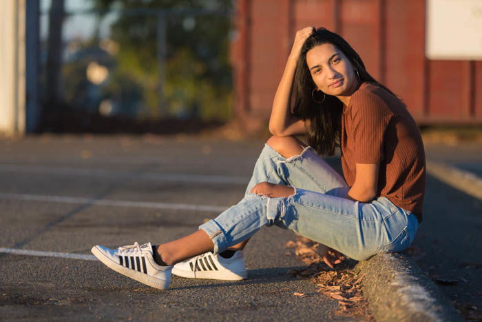 Portrait photo of a woman sitting in a parking lot