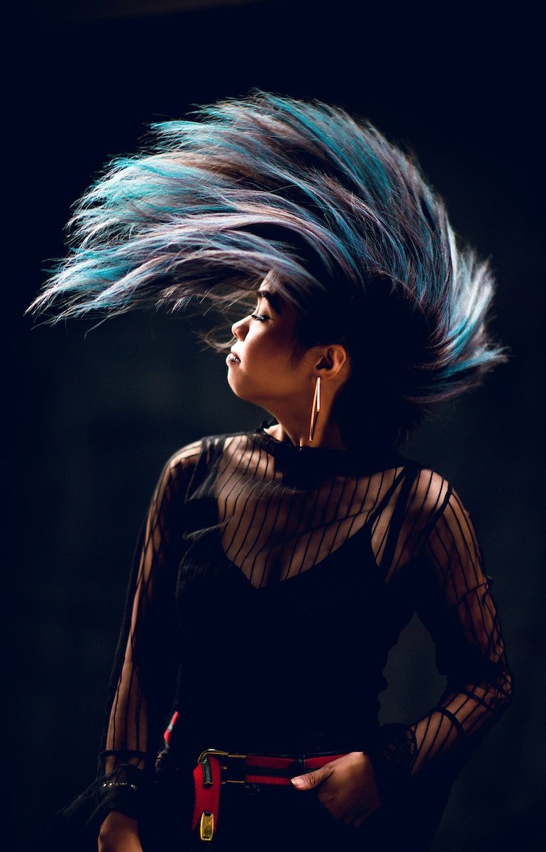 A woman flipping her head and long blue hair up