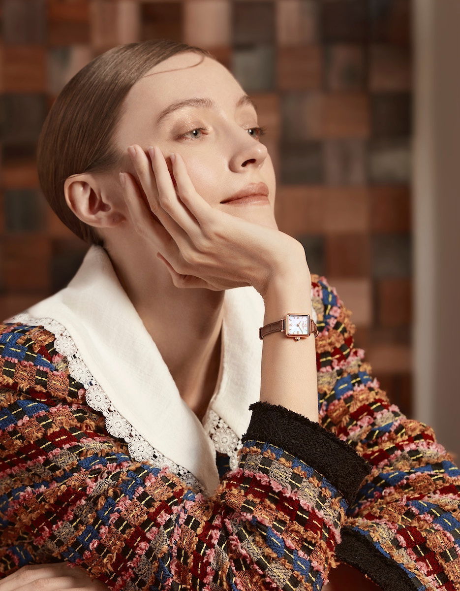 A woman looking up with one hand on her right cheek