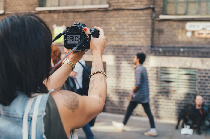  uma fotógrafa tirando uma imagem de rua