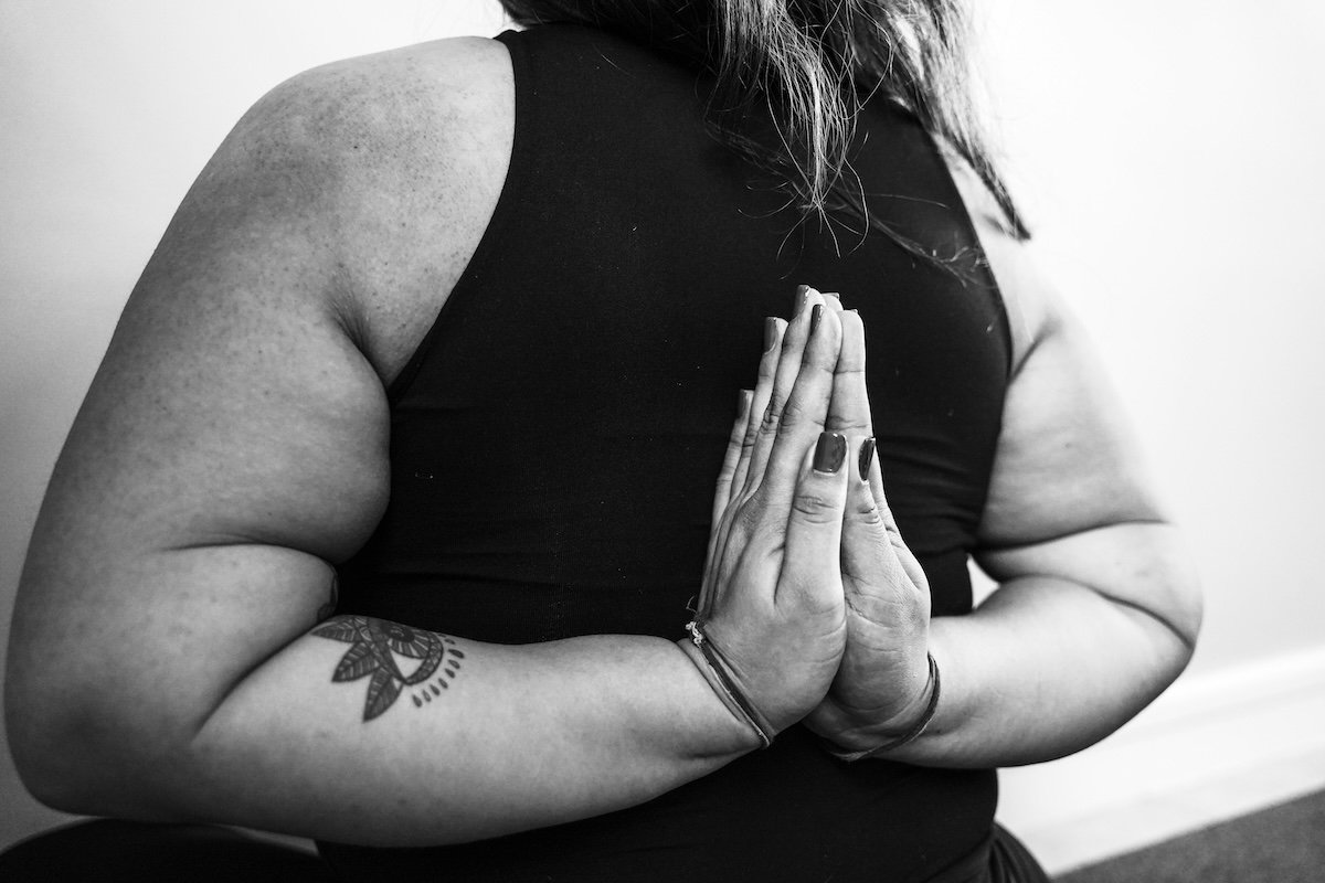 Close-up black-and-white image of yogini with hands behind her back as an example of yoga photography