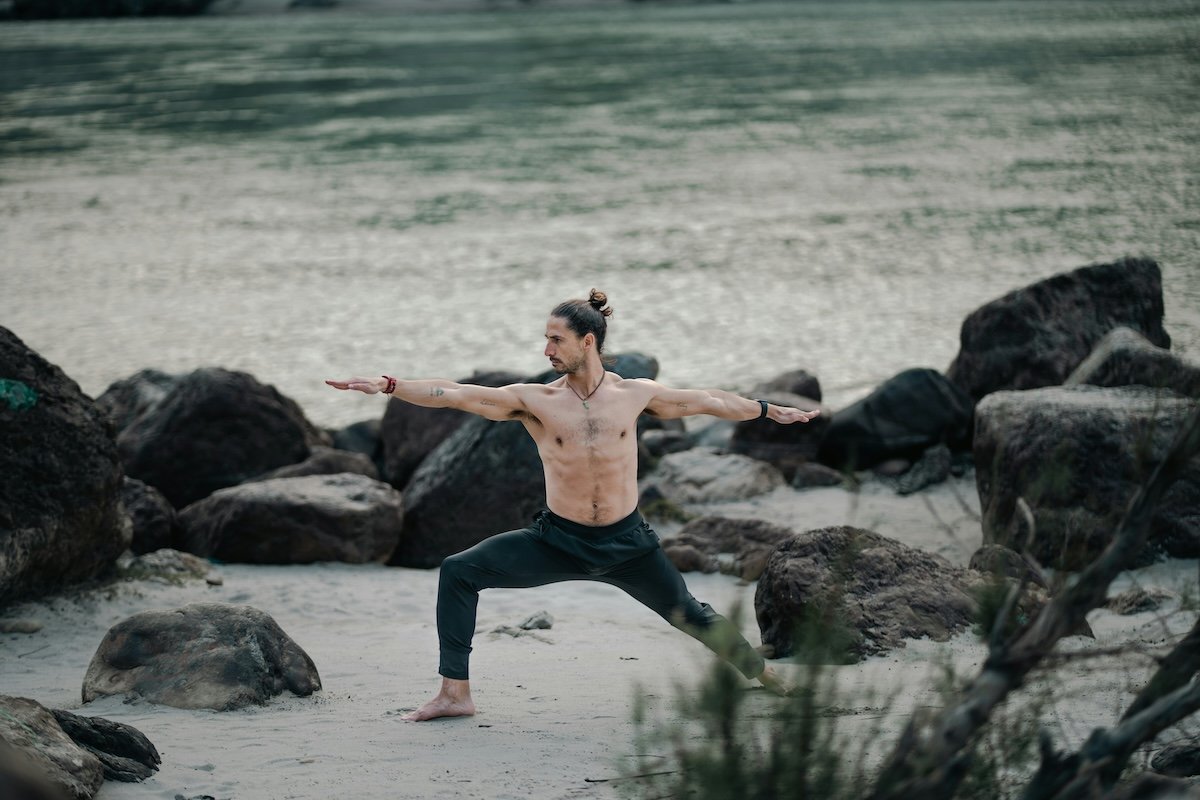 Yogi doing a warrior two pose by water as an example of yoga photography