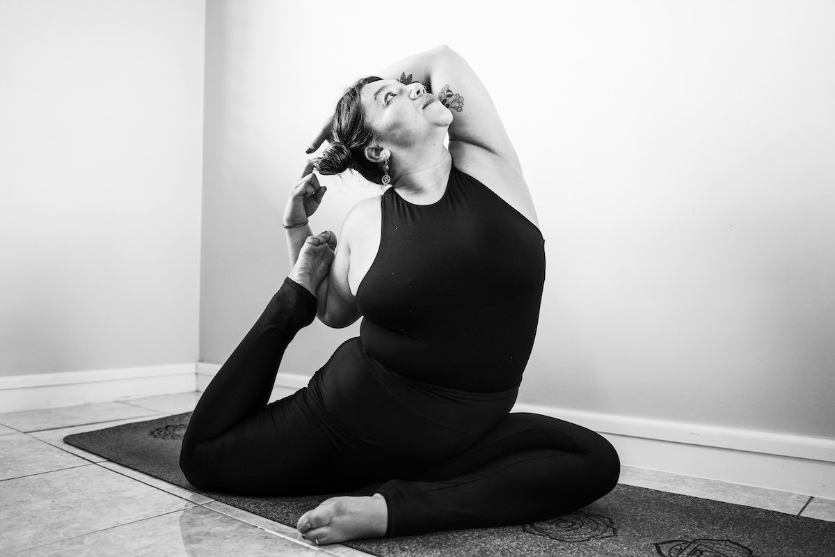 Black-and-white low wide-angle shot of a yogini doing a pigeon pose as an example of yoga photography