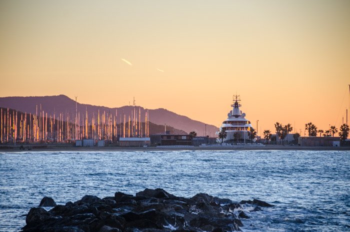 A yacht next to a marina during the golden hour