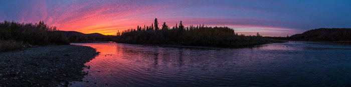 Atmospherica and brightly colored panoramic photo of a sunset in Anvik, Alaska