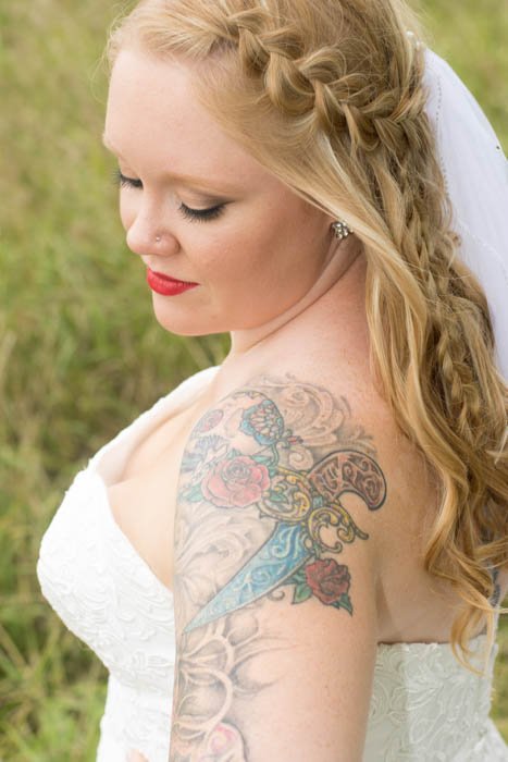 A portrait of a tattooed bride posing outdoors