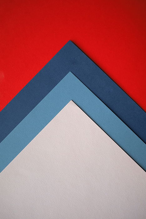 An abstract composition of red, blue and grey colored paper