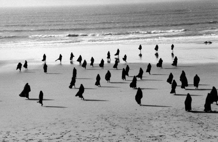 A group of people on a beach by Shirin Neshat