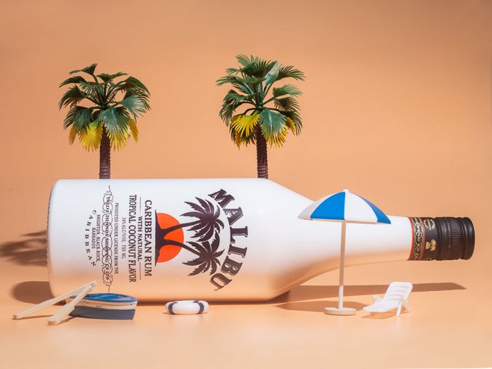 A product photo of a Malibu bottle on a tiny beach scene
