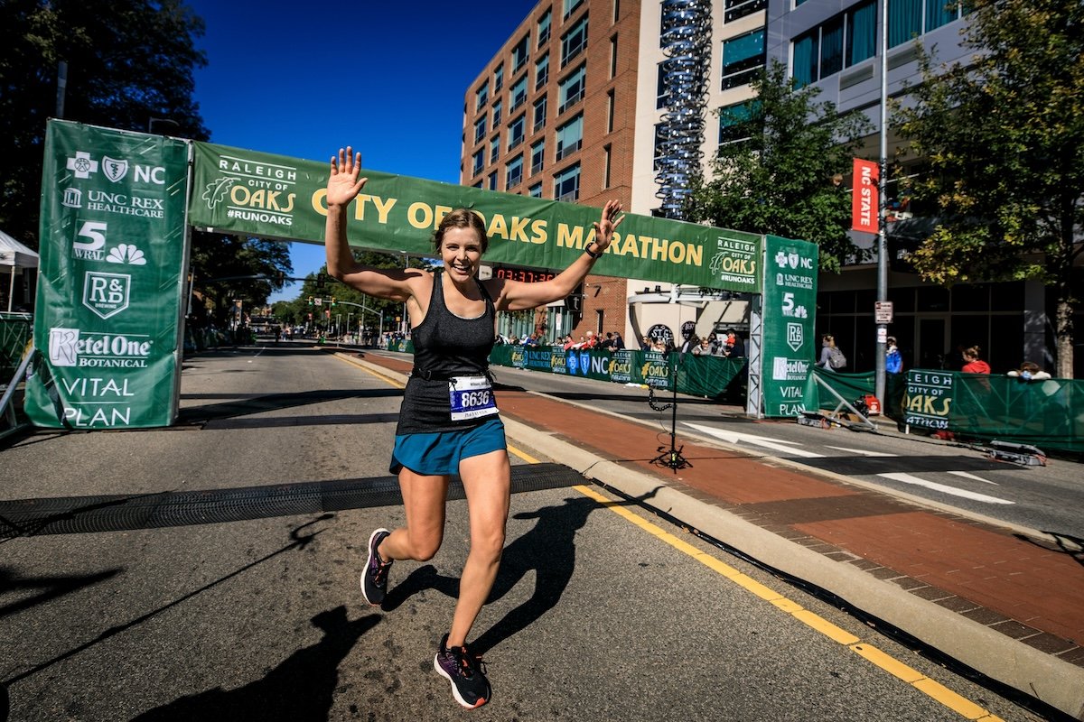 A full-body shot of a runner crossing the finish line as an example of marathon photography
