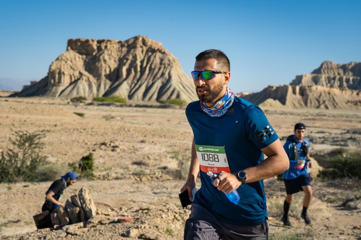 Runner carry a water bottle in the desert as an example of marathon photography