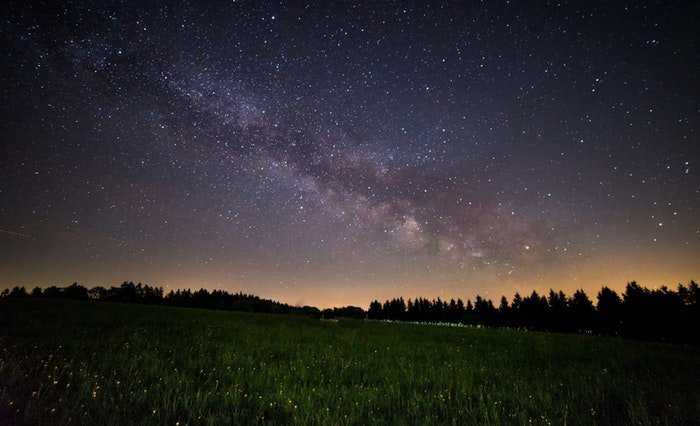 A landscape photo at night with the milky way