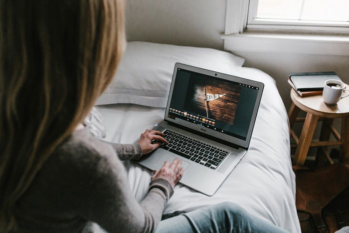 A girl using a laptop on a bed