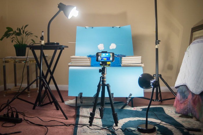 A product photography setup with a smartphone on a tripod in front