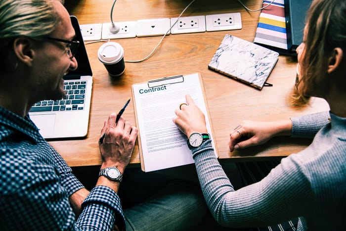 A man and woman negotiating a photography contract in a home office