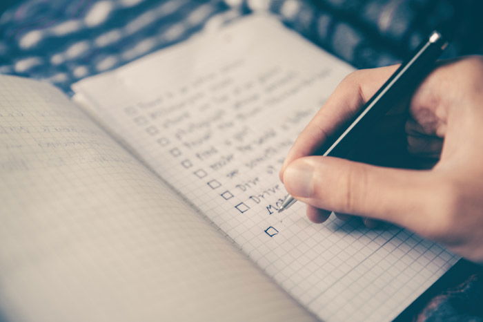 A close up of a person writing a checklist