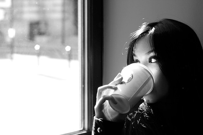 A self-portrait of a woman drinking coffee in a café