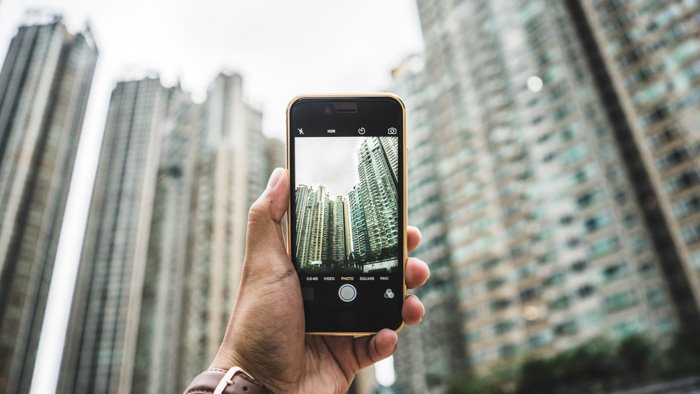A person taking a photo of skyscrapers with a smartphone