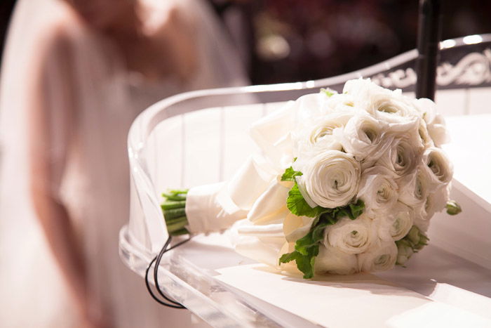 A bridal bouquet with bride sitting in background