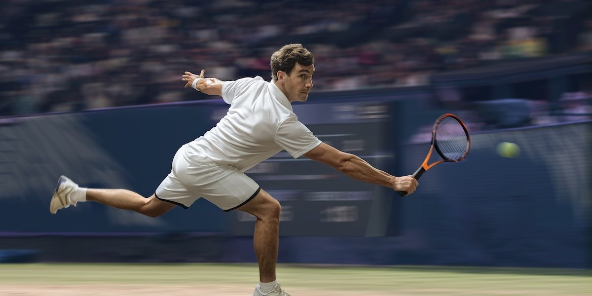 A tennis player lunging to hit a ball as an example of sports photography with blur