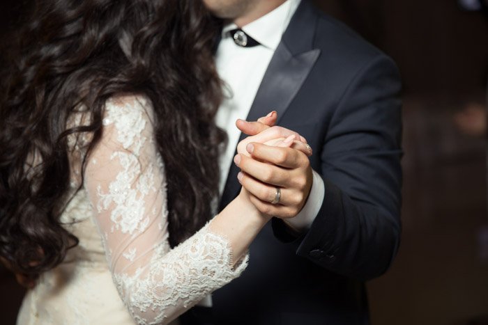 A close up stock photo of a newlywed couple dancing
