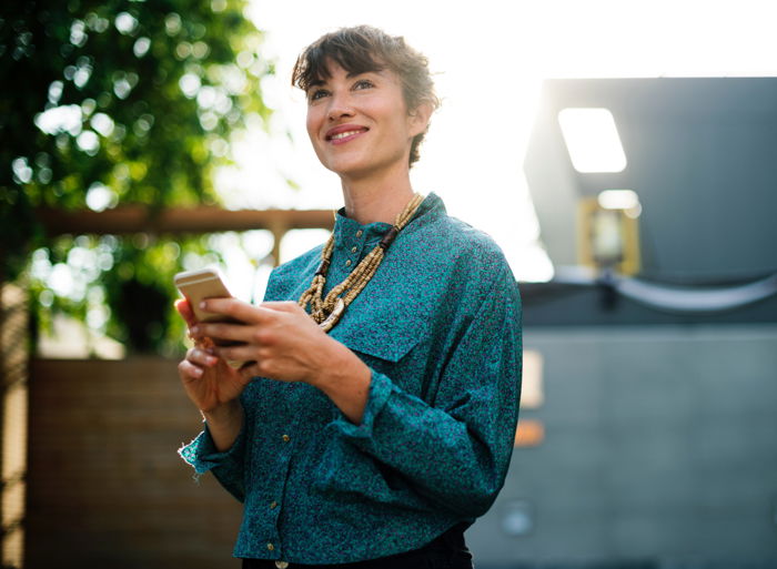  A smiling girl using a smartphone