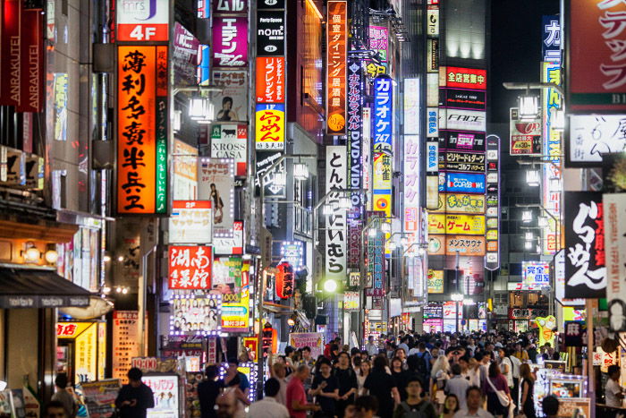 A street photography image with neon hoardings shot in Tokyo at night