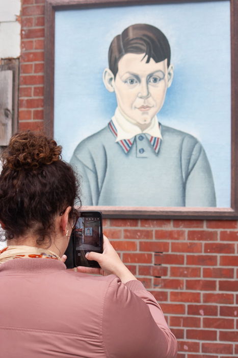 Street photography of a women taking photo of street art