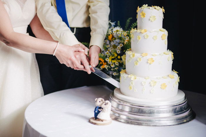 wedding photography of the couple cutting a cake