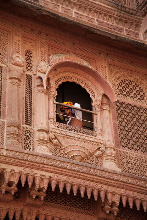 man in window photographed from below