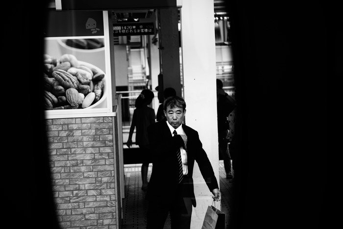 black and white pictures of a man in a suit walking on the street