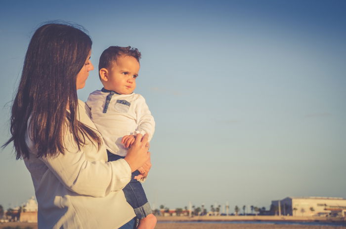 A mother holding a little boy outdoors