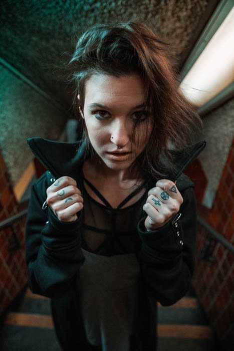 A grungy female photography model posing indoors wearing - fashion photography composition