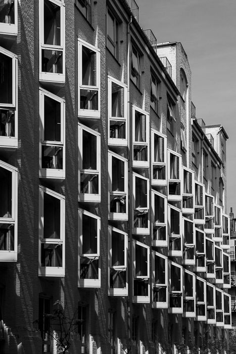 black and white urban photograph of a tall multi windowed building