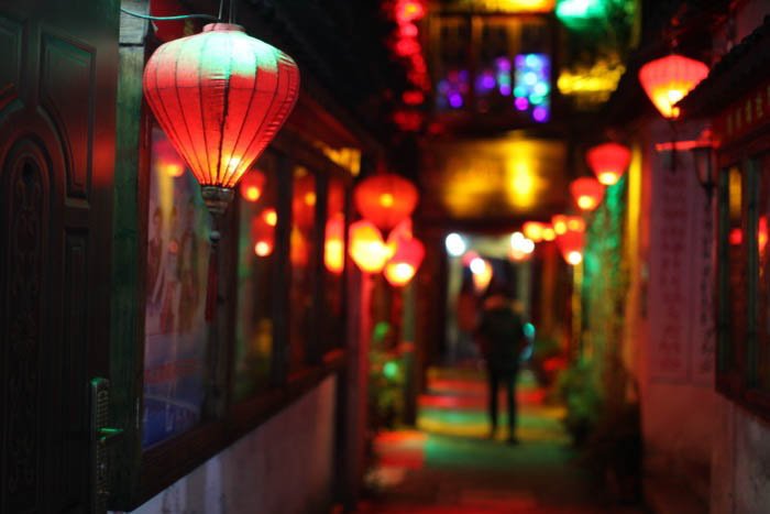 A night street photo of an alley lit by colorful lanterns