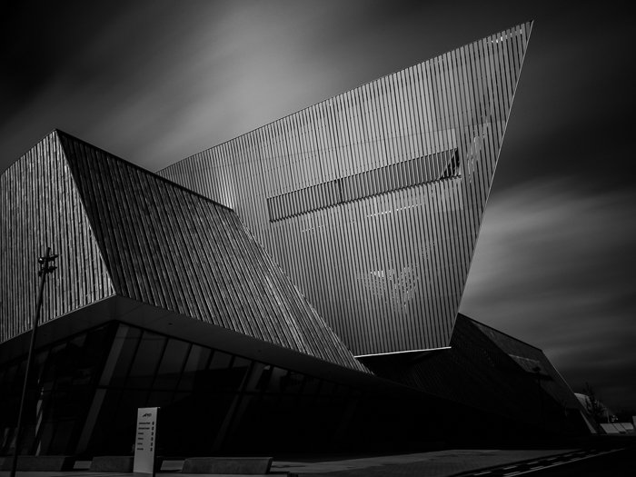 City photography: long exposure black and white photo of The Congress Centre in Mons (Belgium), standing against a dynamic sky with fast moving clouds