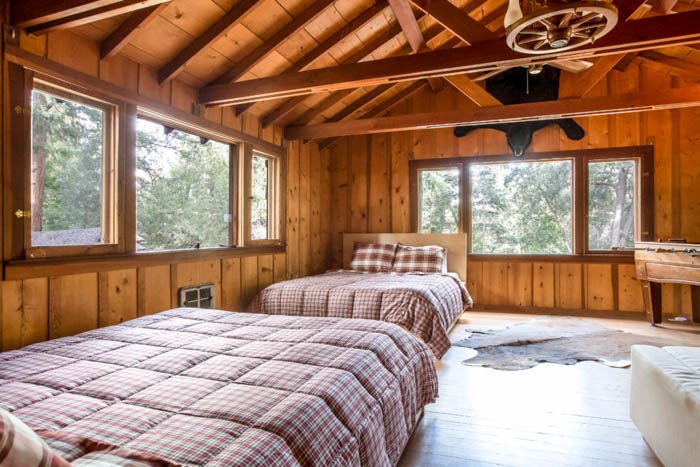 interior photo of a cabin with two beds and large windows