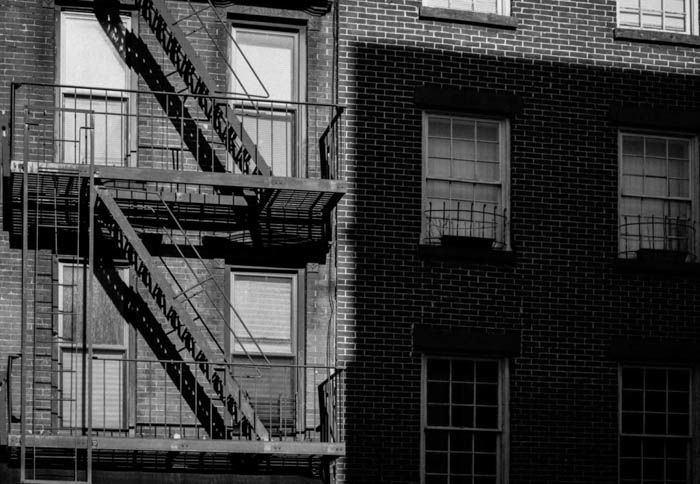 Greyscale photo of a stairway on the exterior of a building