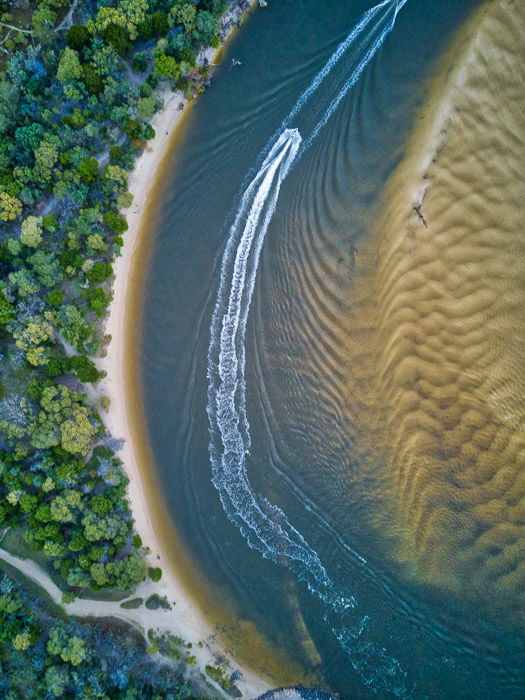 drone photography capturing the contrasting textures of a forest, coast, water and sand 