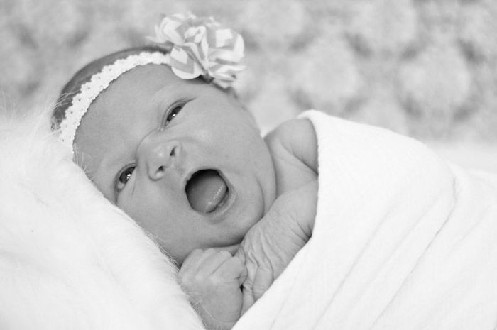 A black and white portrait of a newborn baby